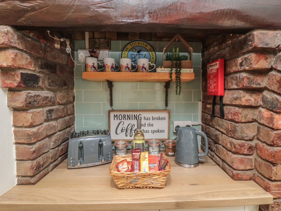 A kitchen area with a kettle, toaster, mugs, and a basket at Bobbies' Retreat, 20 High Street, Bridlington