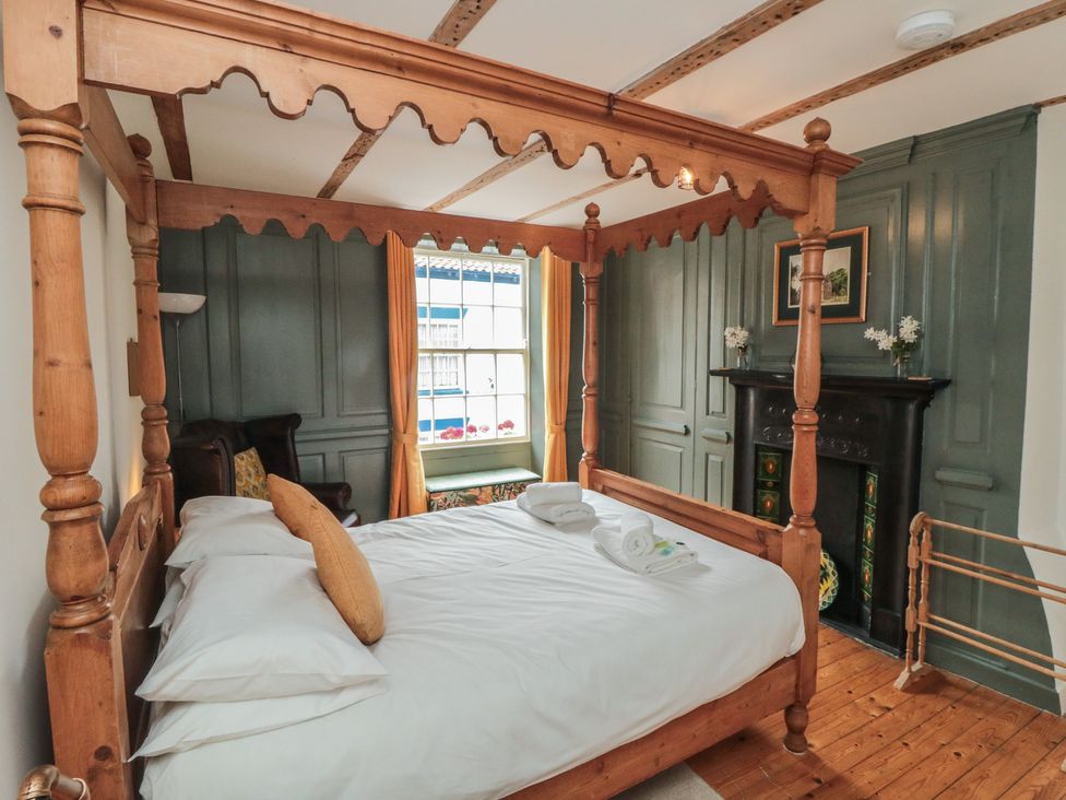A bedroom with a four-poster bed and wooden furniture at Bobbies' Retreat, 20 High Street, Bridlington