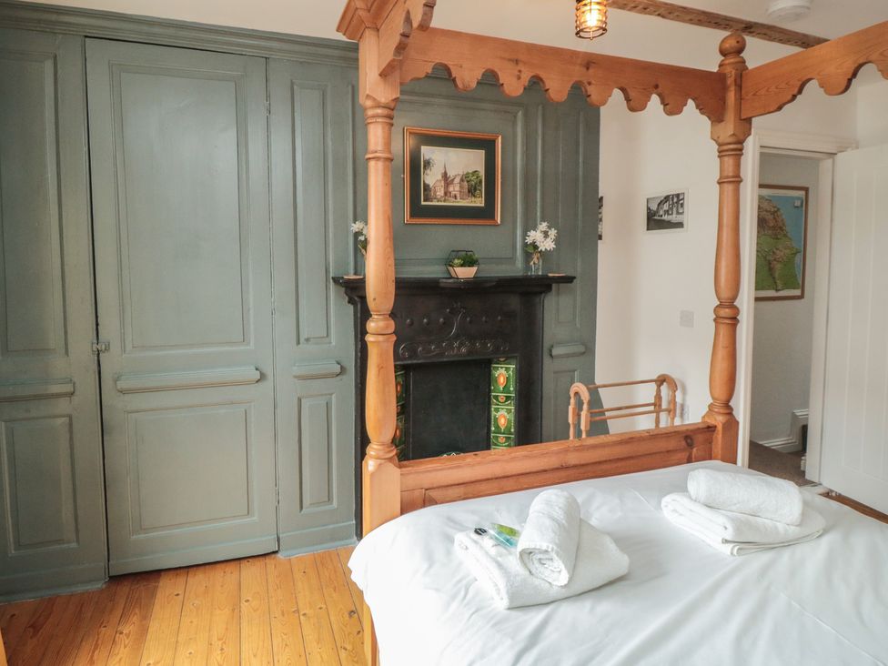 A bedroom with a four-poster bed and a fireplace at Bobbies' Retreat, 20 High Street, Bridlington