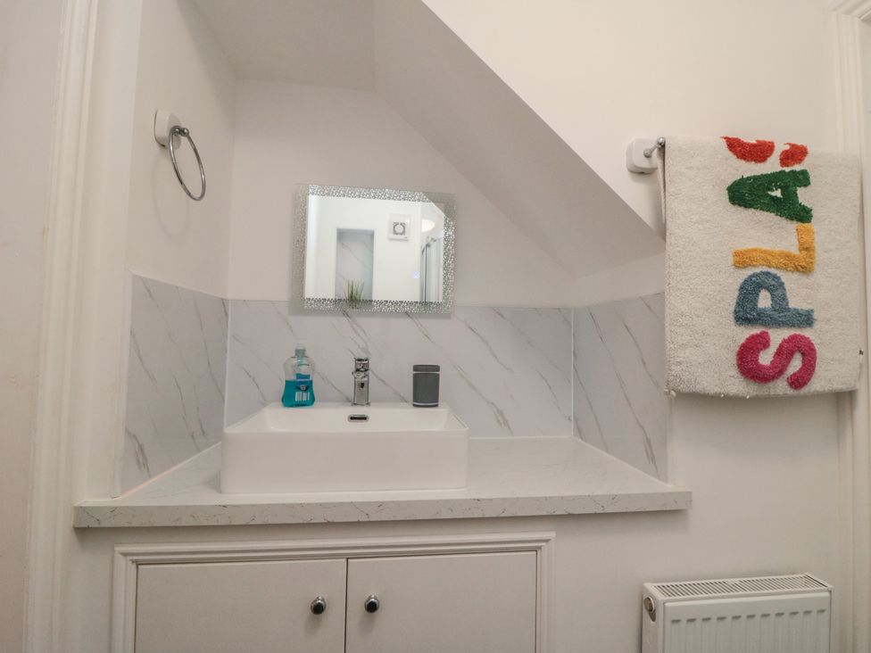 A bathroom with a sink and mirror at Bobbies' Retreat, 20 High Street, Bridlington
