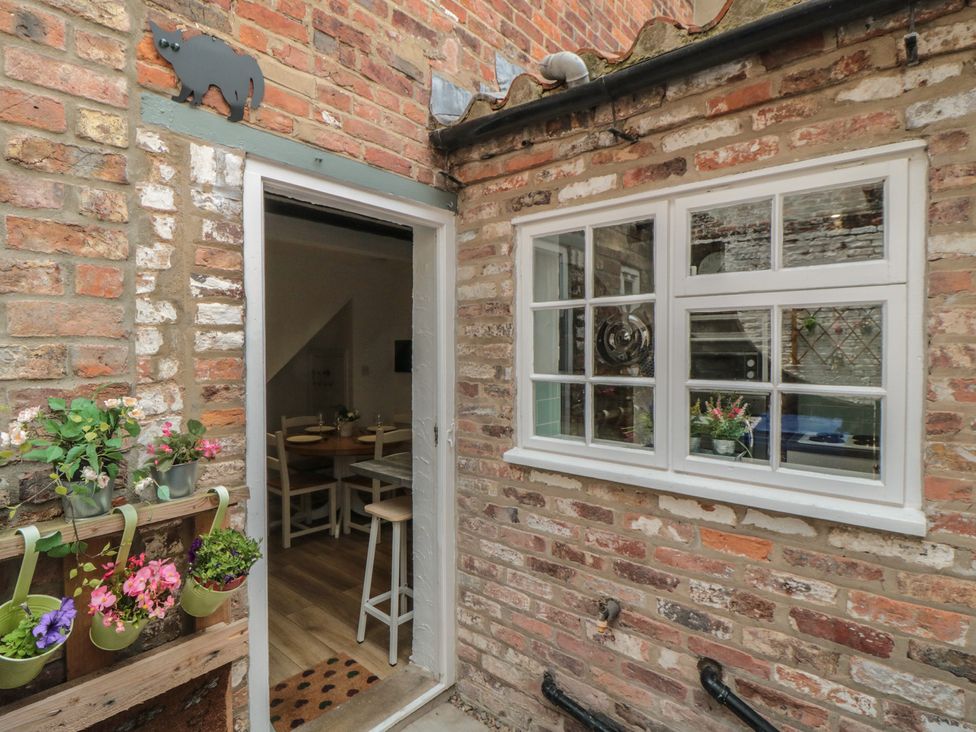 An entrance with potted plants and a dining area visible at Bobbies' Retreat, 20 High Street, Bridlington