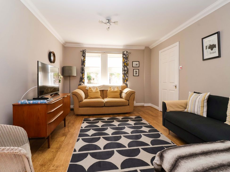 A living room with a television and sofas at 8 Williamson Drive in Ripon
