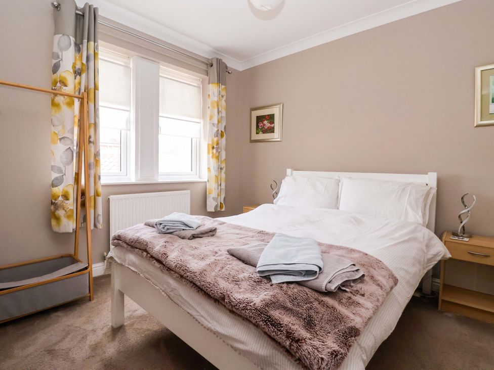 A bedroom with a bed and curtains at 8 Williamson Drive Ripon