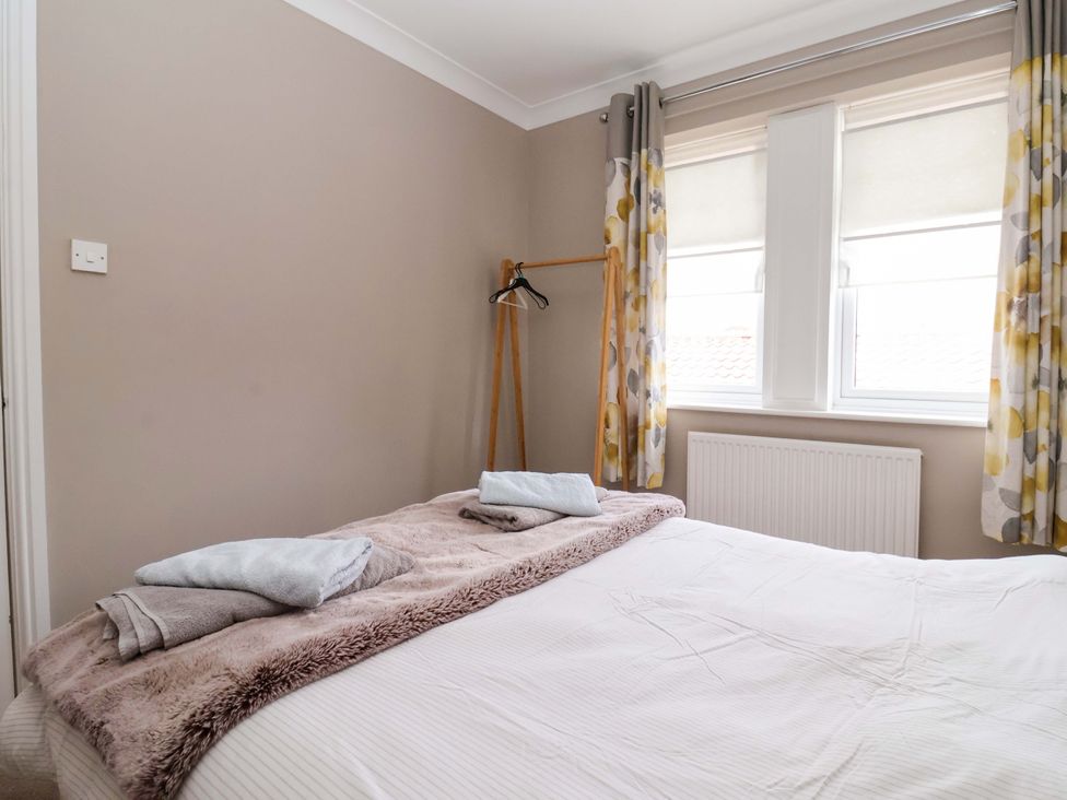 A bedroom with a bed and towels at 8 Williamson Drive Ripon