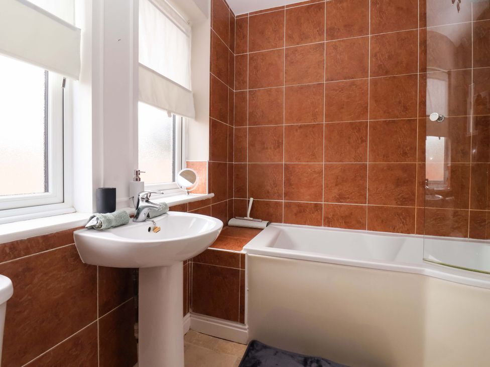 A bathroom with a bathtub and sink at 8 Williamson Drive in Ripon