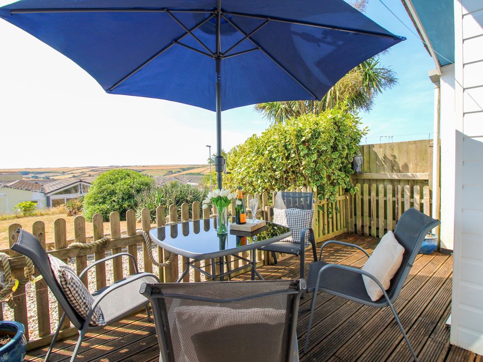 An outdoor seating area with table and chairs at Merlin in Malborough