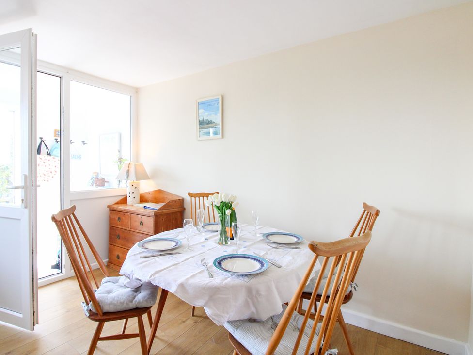 A dining room with a table set for four at Merlin in Malborough