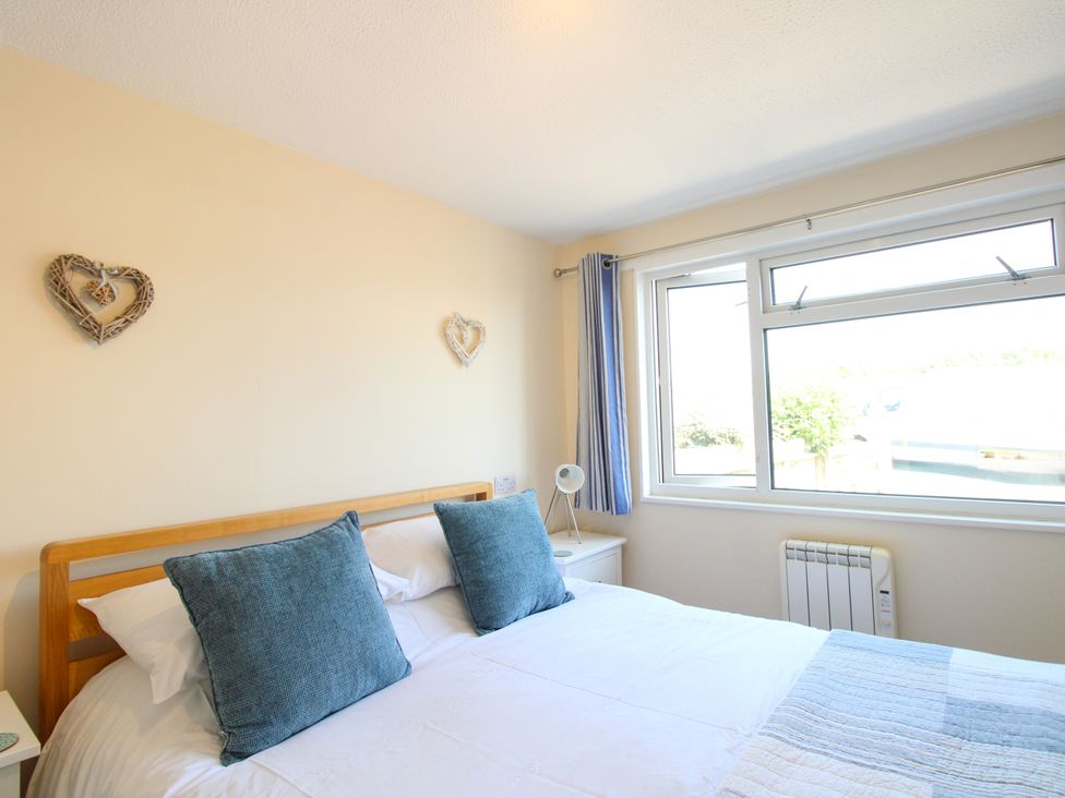 A bedroom with a bed and window at Merlin in Malborough
