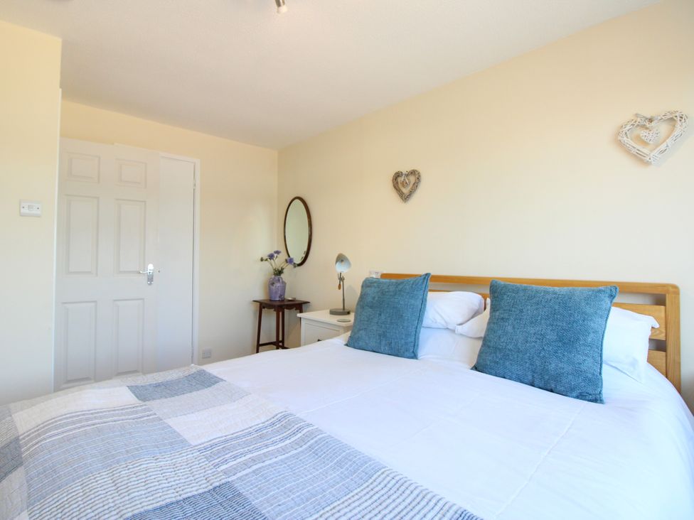 A bedroom with a bed and lamp at Merlin in Malborough