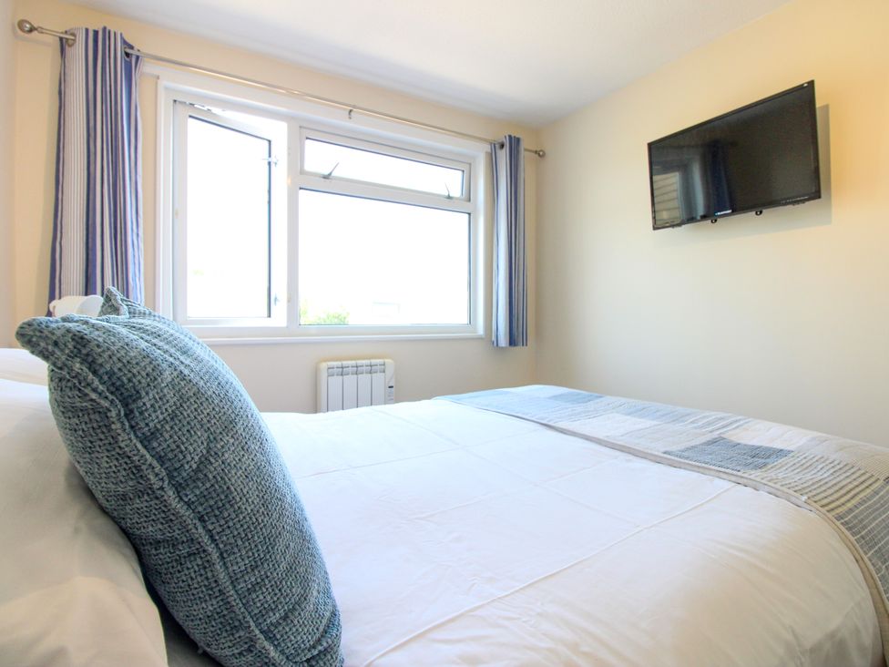 A bedroom with a bed and a television mounted on the wall at Merlin in Malborough