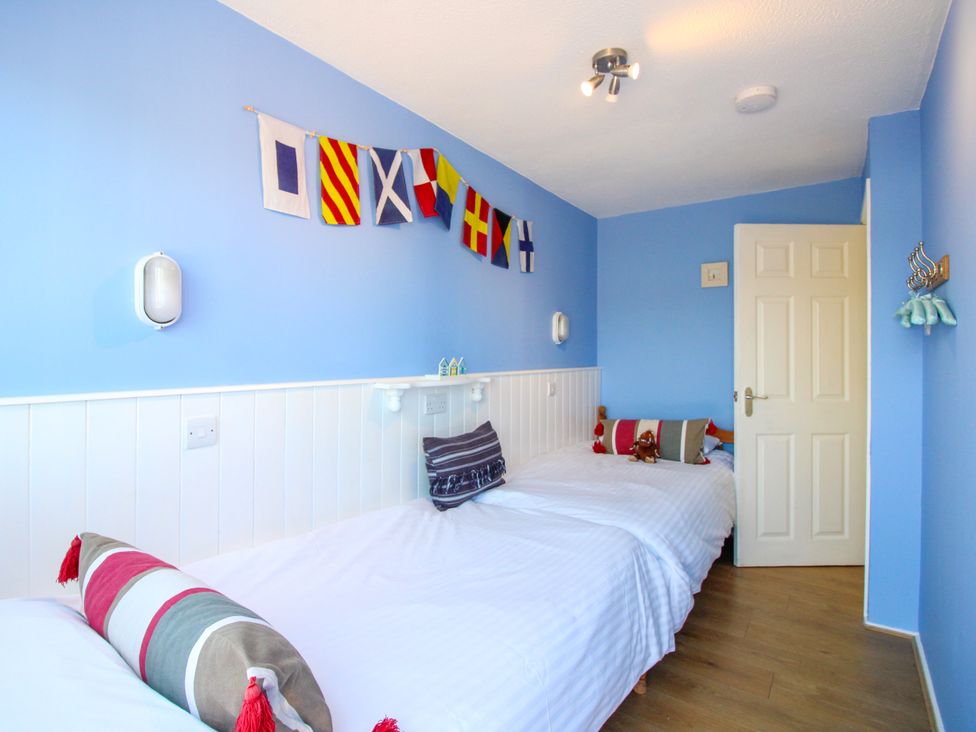 A bedroom with two beds and nautical flags at Merlin in Malborough