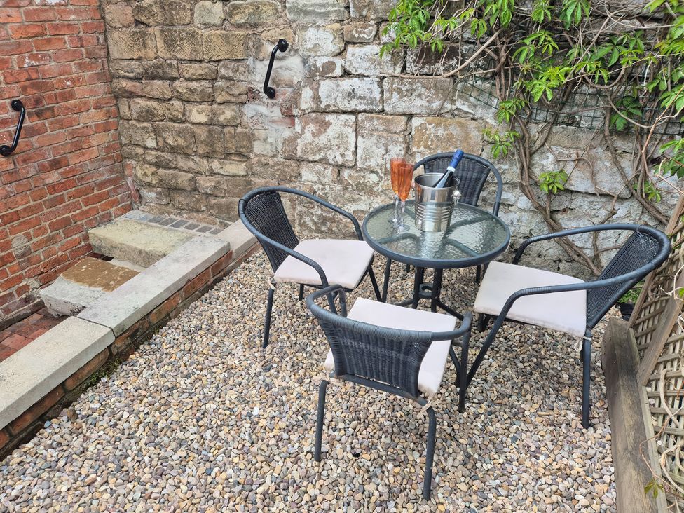 An outdoor seating area with a table and chairs at Chestnuts Barn in Holbrook, Derbyshire