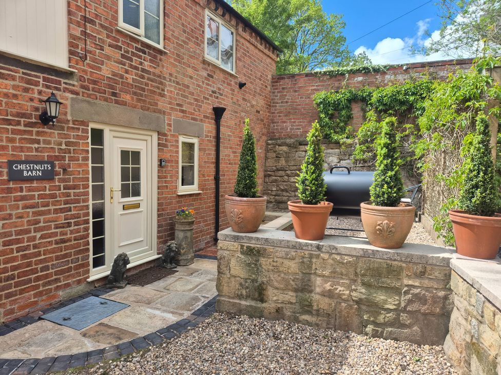 An outdoor area with potted plants and a barbecue at Chestnuts Barn Holbrook Derbyshire