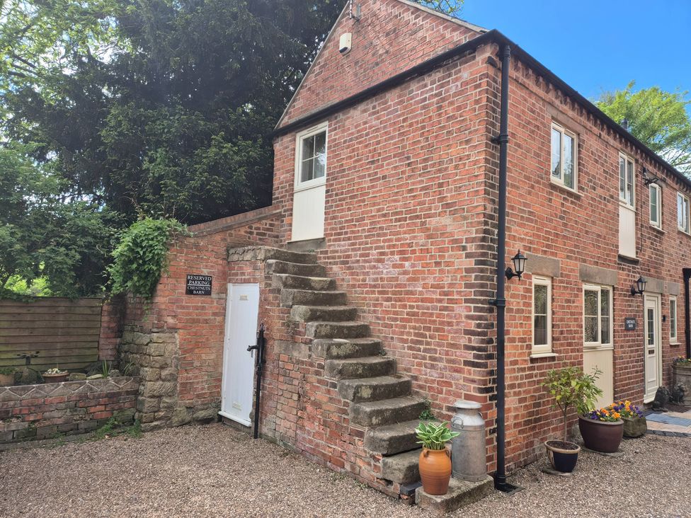 An exterior view of a brick building with stairs and door at Chestnuts Barn Holbrook, Derbyshire