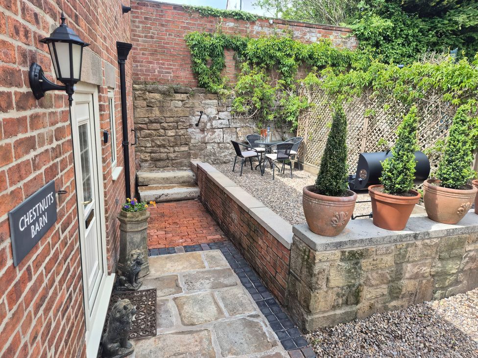 A patio area with a table and chairs at Chestnuts Barn Holbrook, Derbyshire