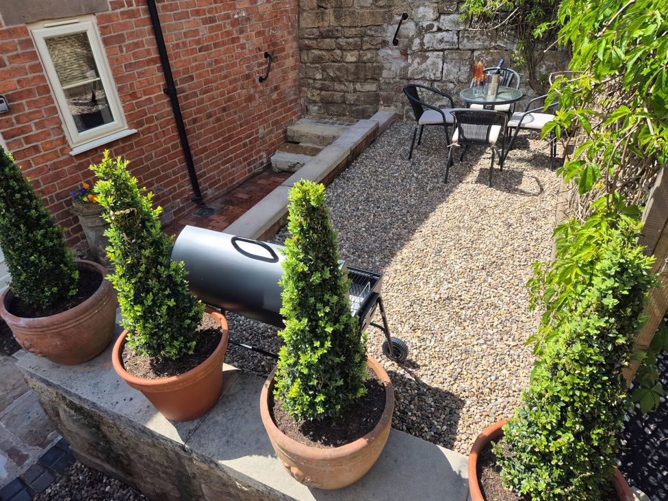 A garden area with potted plants and a seating arrangement at Chestnuts Barn, Holbrook, Derbyshire