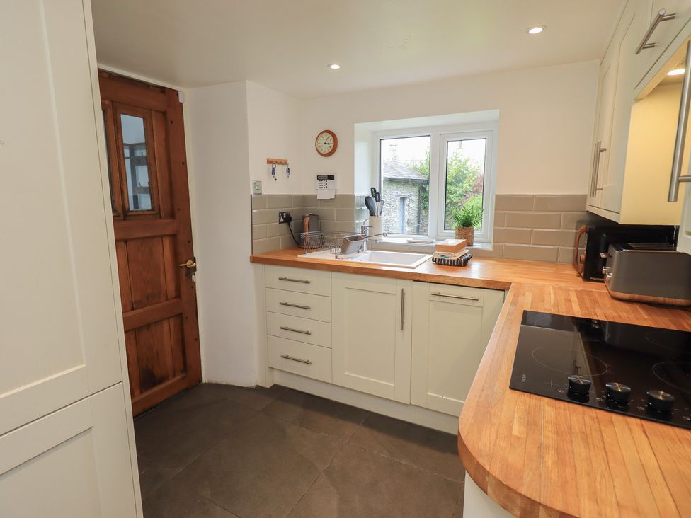 A kitchen with a sink and window at Green Stile Cottage in Bowness-On-Windermere