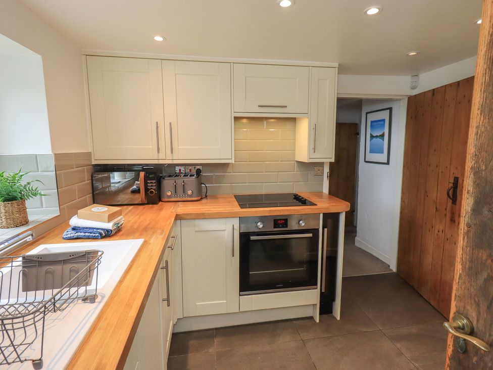 A kitchen with appliances and cabinets at Green Stile Cottage in Bowness-On-Windermere