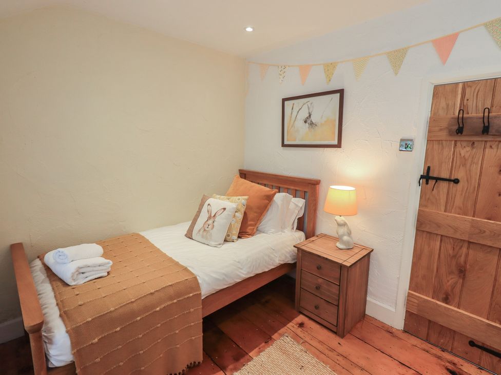 A bedroom with a single bed and bedside table at Green Stile Cottage in Bowness-On-Windermere