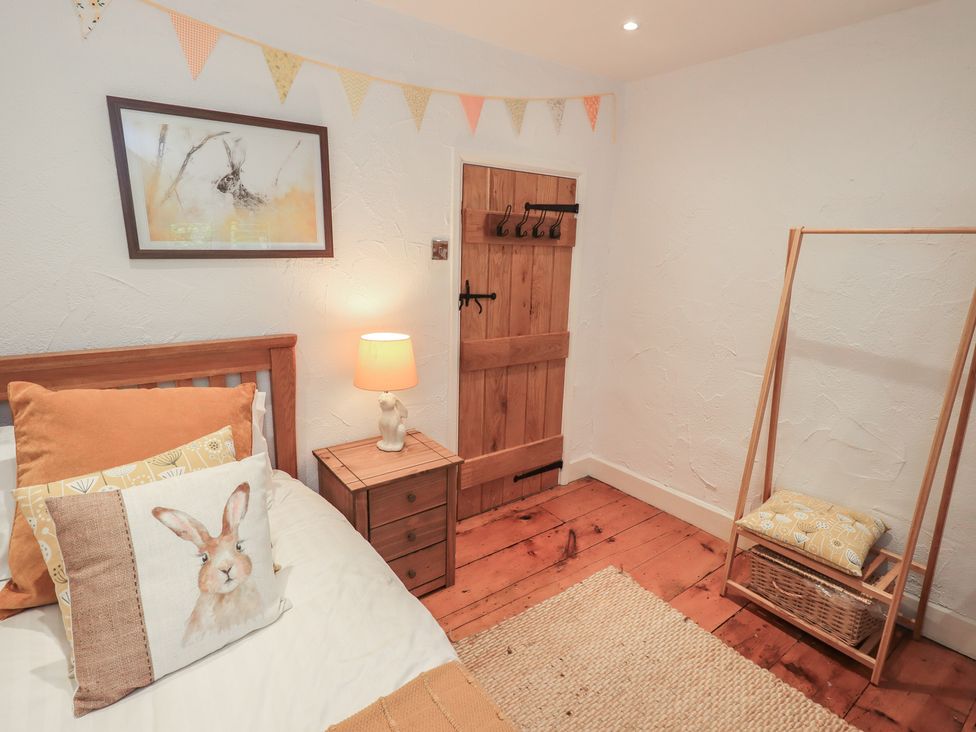 A bedroom with a bed and nightstand at Green Stile Cottage in Bowness-On-Windermere