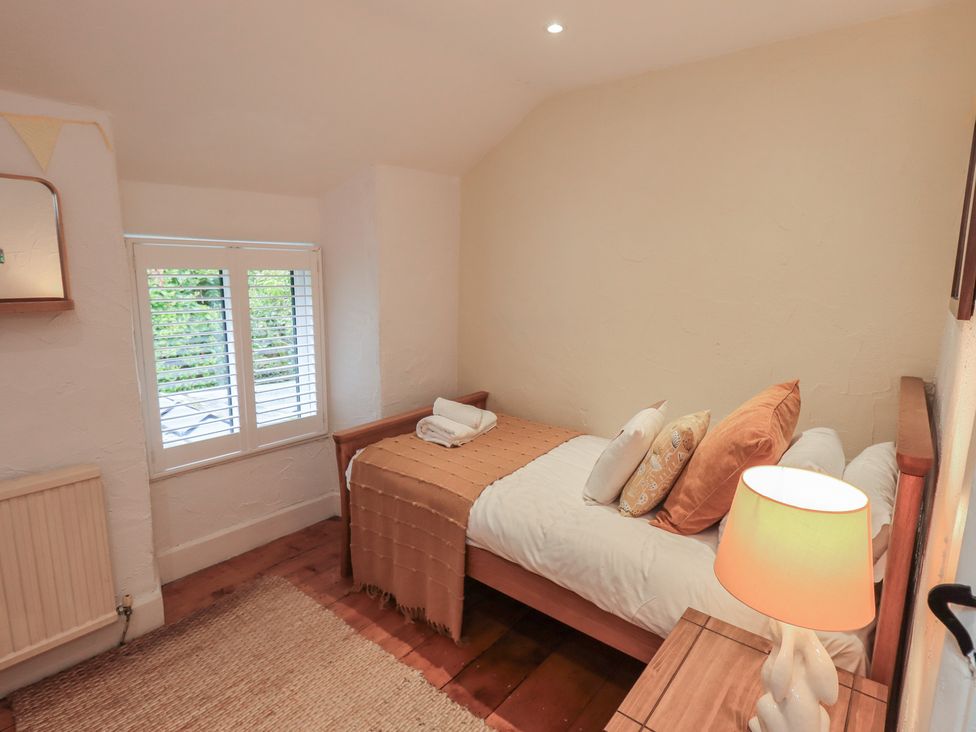 A bedroom with a bed and window at Green Stile Cottage Bowness-On-Windermere