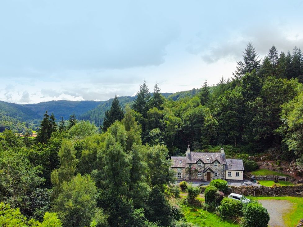 A house surrounded by trees and mountains at Greffyn in Betws-Y-Coed