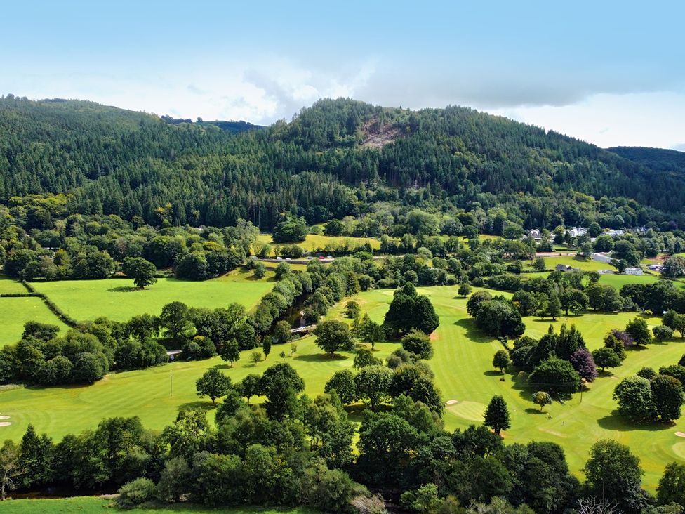 A landscape view of a golf course surrounded by trees at Greffyn in Betws-Y-Coed
