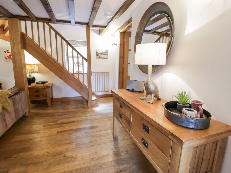 An entrance hall with a console table and staircase at Greffyn in Betws-Y-Coed