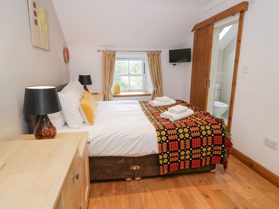 A bedroom with a bed and lamp at Greffyn in Betws-Y-Coed