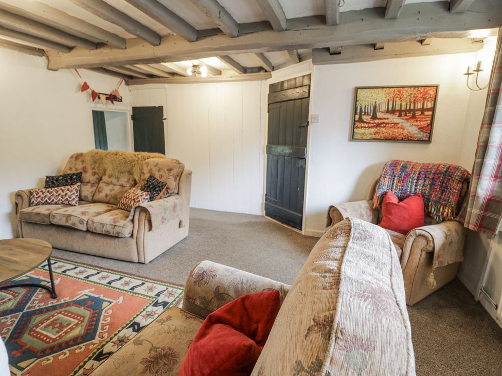 A living room with sofas and a coffee table at Orsedd Wen Farmhouse Betws-Y-Coed