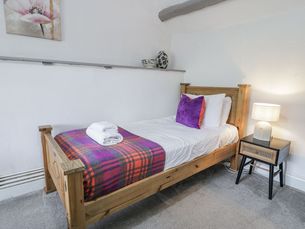 A bedroom with a single bed and lamp at Orsedd Wen Farmhouse in Betws-Y-Coed