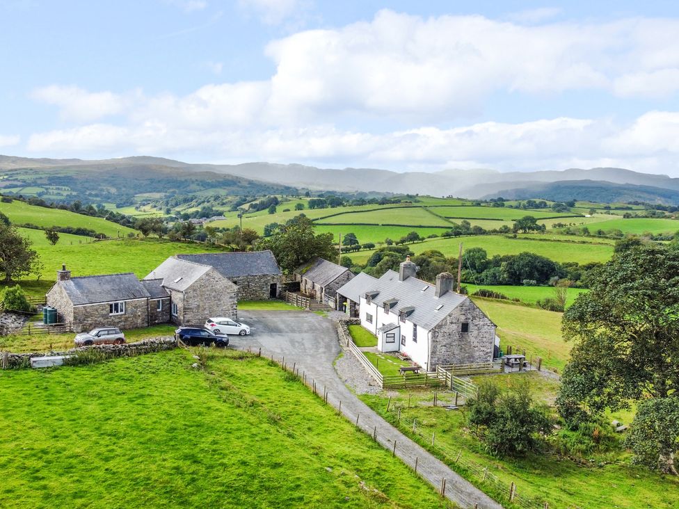 A farmhouse with several buildings and cars at Orsedd Wen Farmhouse in Betws-Y-Coed