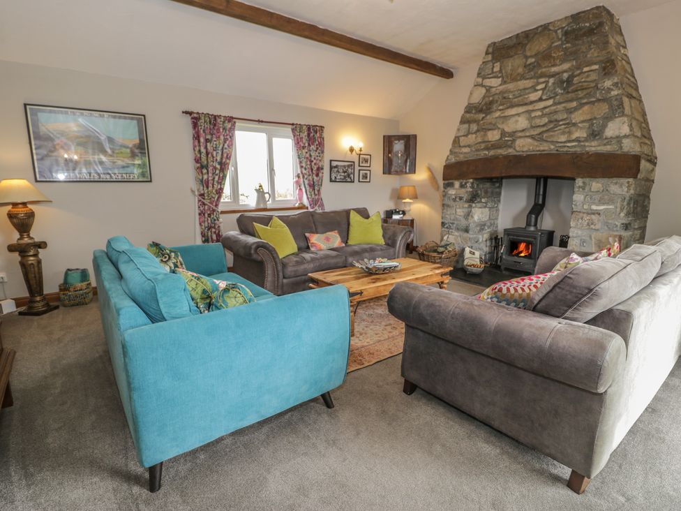 A living room with sofas and a fireplace at Orsedd Wen Cottage in Betws-Y-Coed