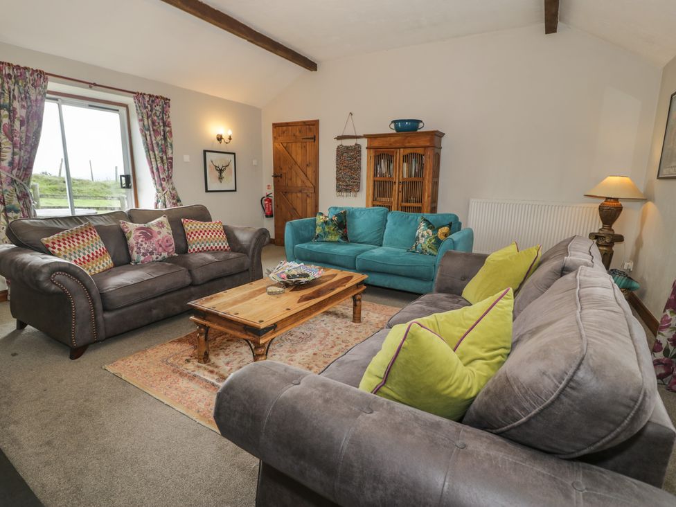 A living room with sofas and a coffee table at Orsedd Wen Cottage in Betws-Y-Coed