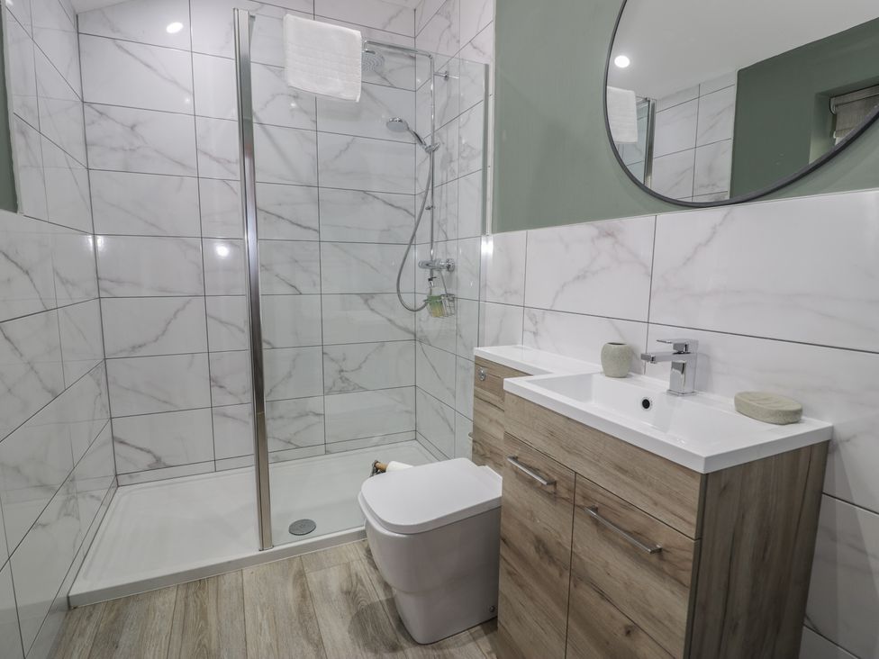 A bathroom with a shower, sink, and toilet at Orsedd Wen Cottage Betws-Y-Coed