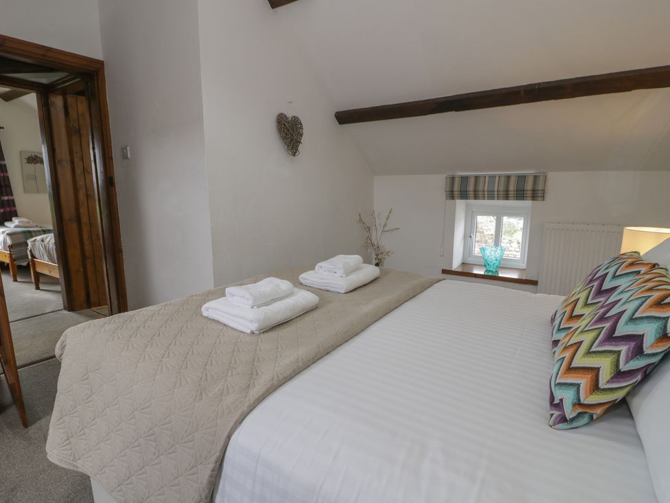A bedroom with a bed and towels at Orsedd Wen Cottage in Betws-Y-Coed