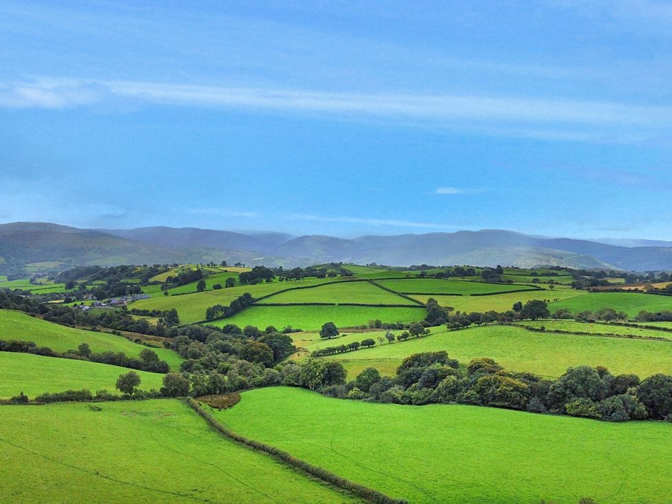 A panoramic view of green fields and hills at Orsedd Wen Cottage in Betws-Y-Coed