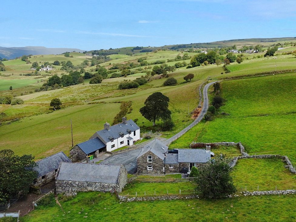 A house surrounded by fields and trees at Orsedd Wen Cottage in Betws-Y-Coed