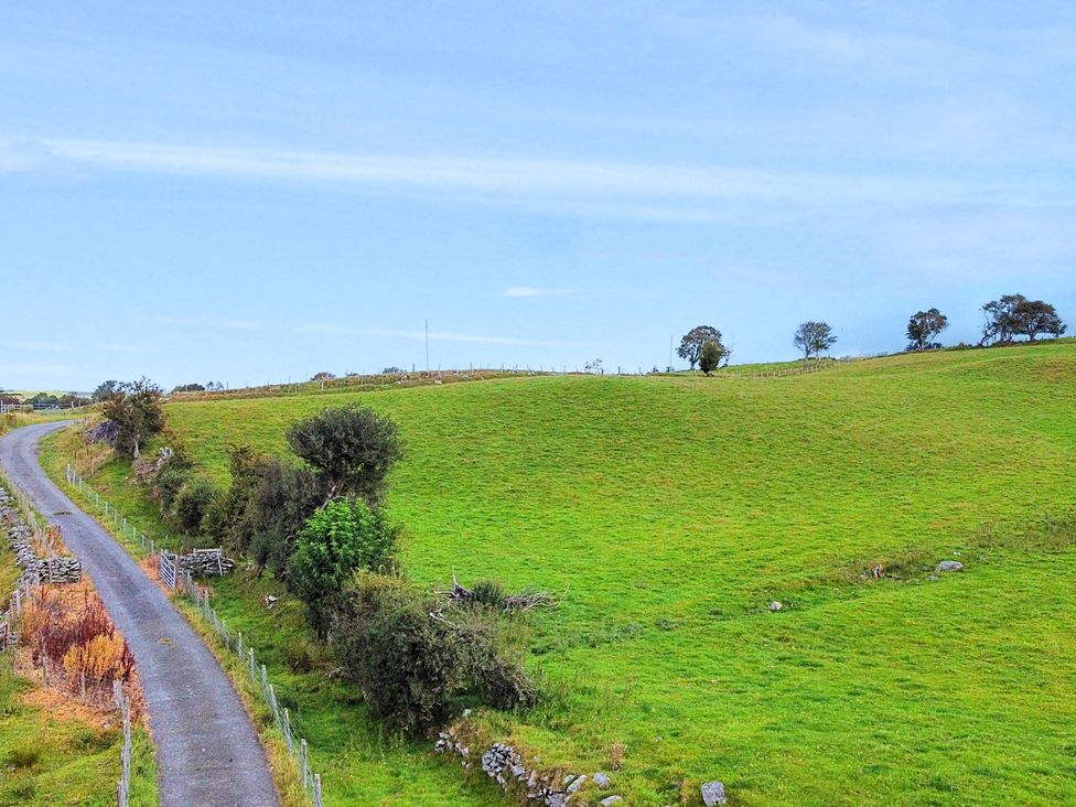 A landscape with a winding road and green hills at Orsedd Wen Cottage in Betws-Y-Coed