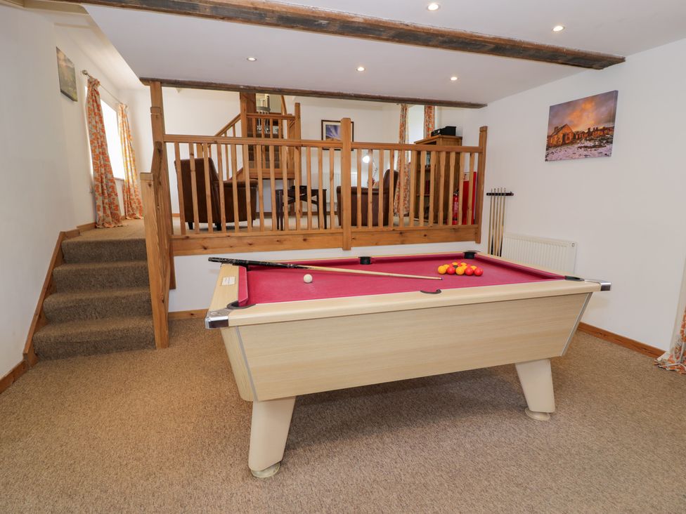 A game room with a pool table and stairs at Cwm in Capel Curig