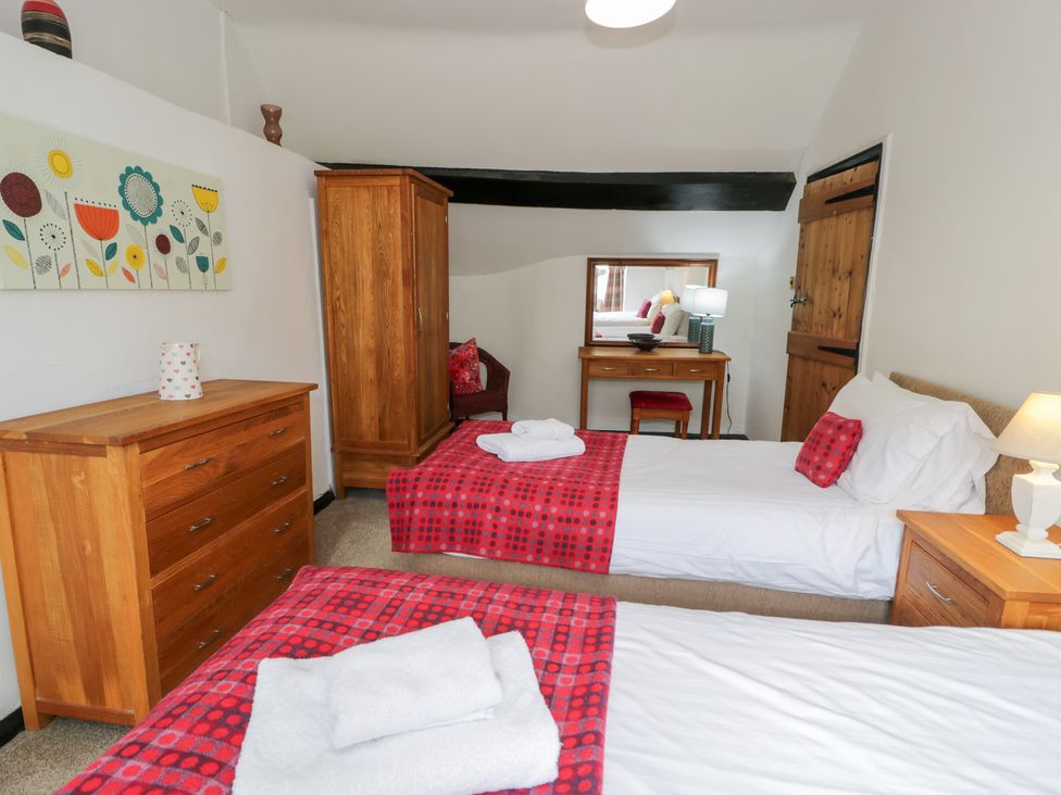 A bedroom with twin beds and wooden furniture at Cwm in Capel Curig