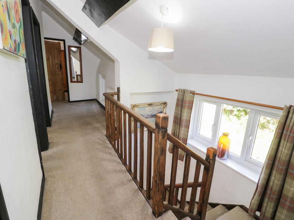 A hallway with a staircase and window at Cwm in Capel Curig