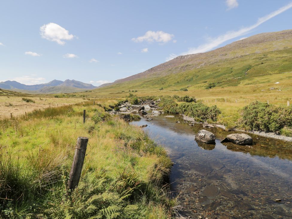 A scenic view of mountains and a stream in Cwm, Capel Curig