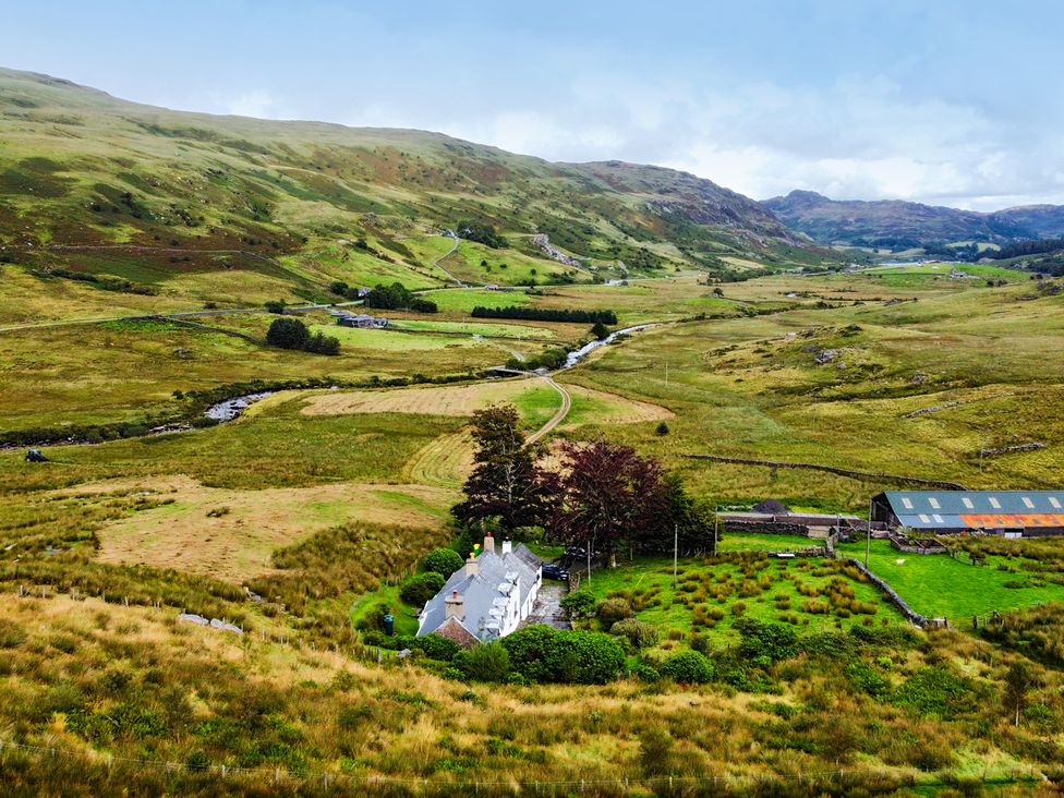 A cottage surrounded by trees and fields in Cwm, Capel Curig