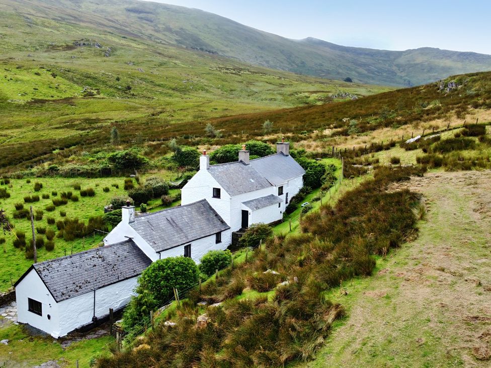 A cottage surrounded by grass and hills at Cwm in Capel Curig