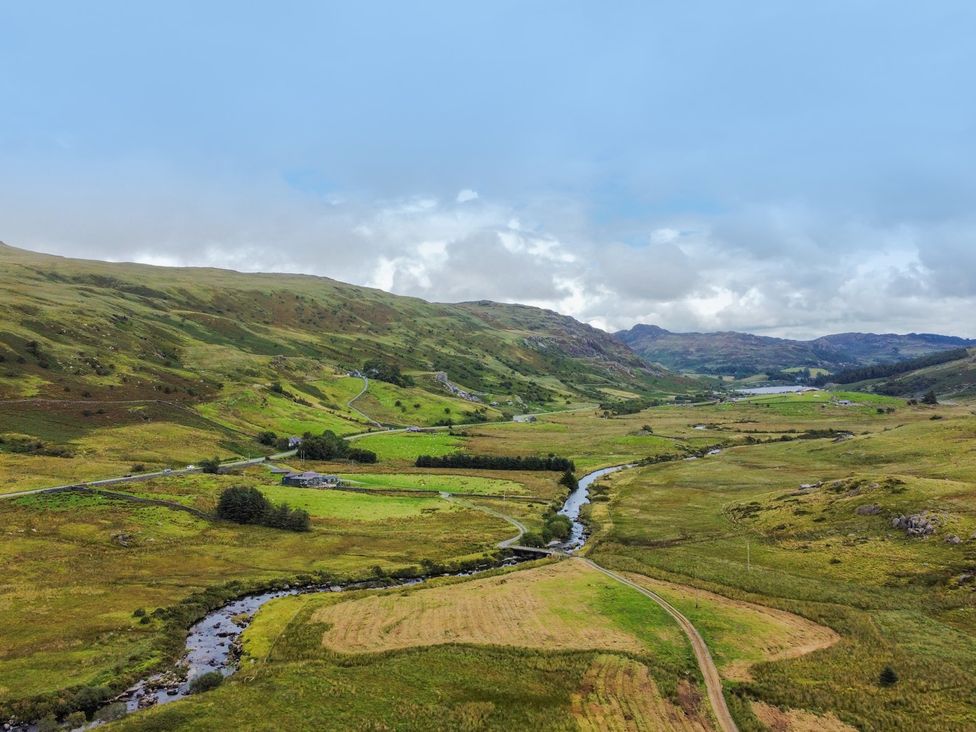 A landscape with a river and fields at Cwm in Capel Curig
