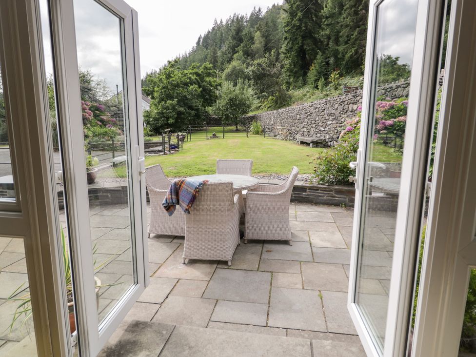 An outdoor seating area with a table and chairs at Pengwern Bach in Llanrwst