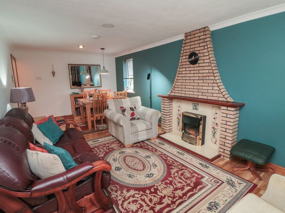 A living room with a fireplace and dining area at 17 Costa Way, Pickering