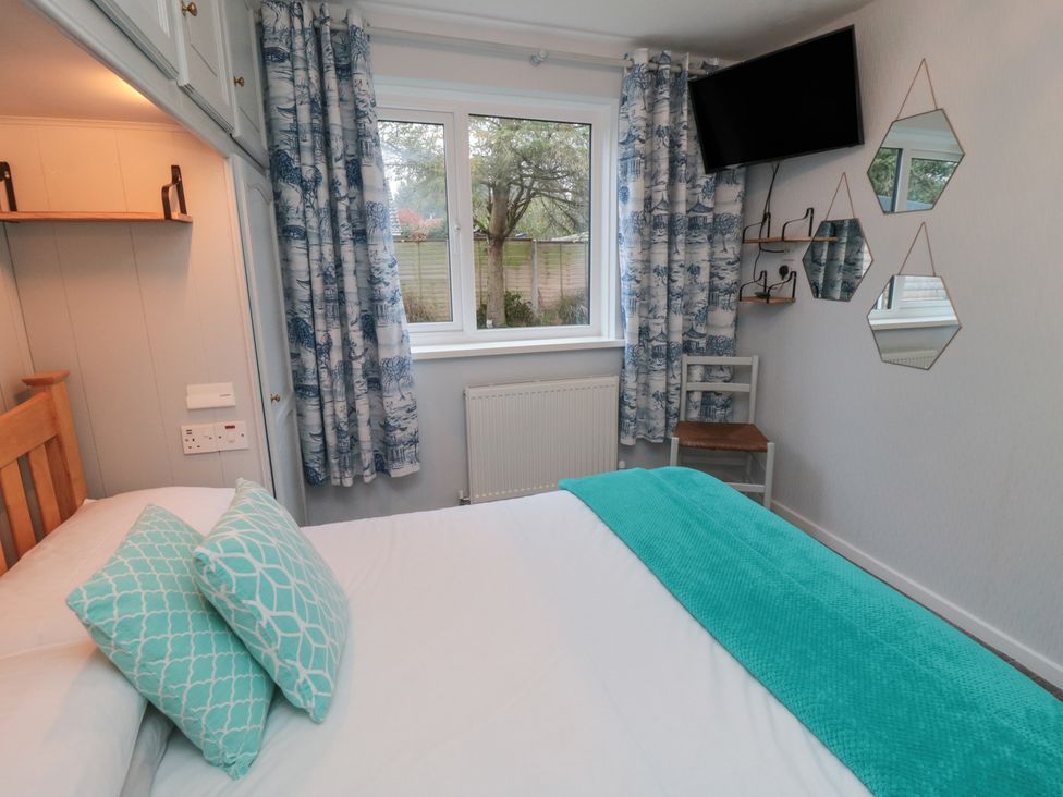 A bedroom with a window and TV at 17 Costa Way in Pickering