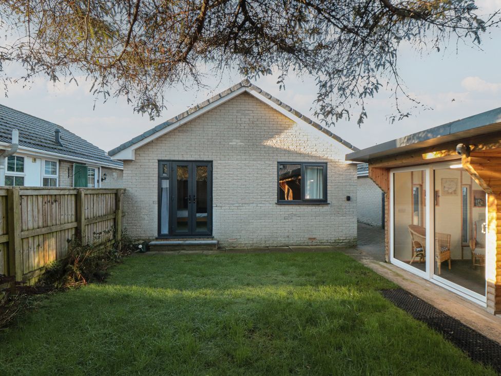 A garden with a house and fence at 17 Costa Way in Pickering